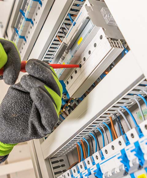 Un électricien qui travail sur un tableau électrique