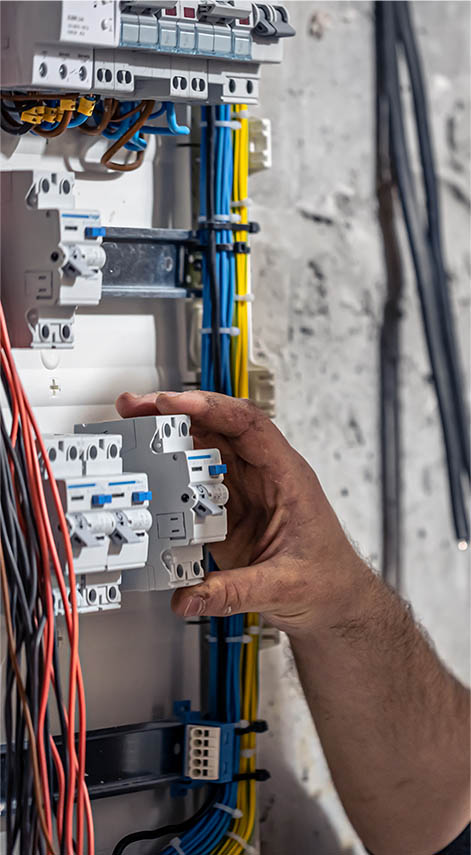 Un électricien qui répare un tableau électrique