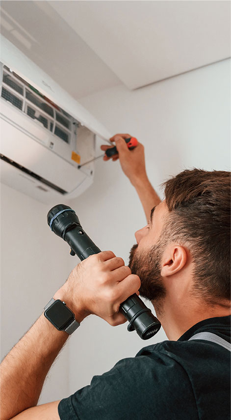 Un technicien qui répare une climatisation